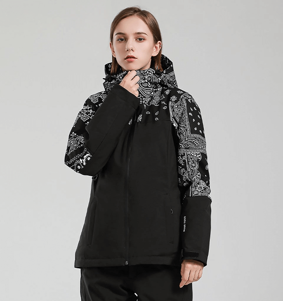 Woman wearing black ski jacket with hood featuring a windproof, waterproof design for winter sports.